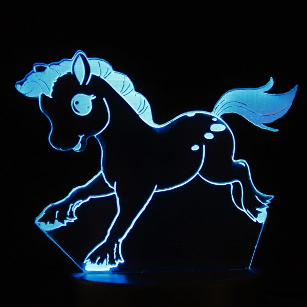 A laser cut design of a cartoon pony, illuminated in blue