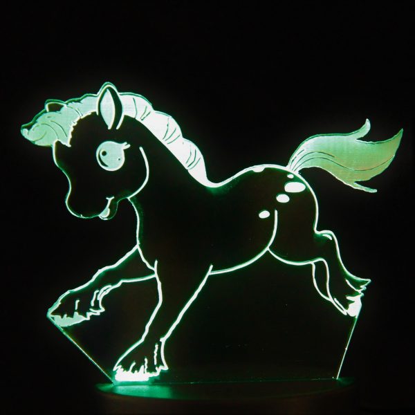 A laser cut design of a cartoon pony, illuminated in green