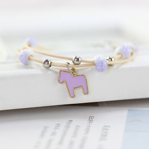 A bracelet with beads and a small purple horse charm