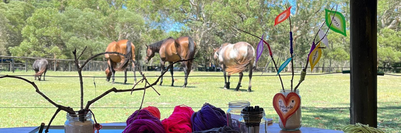 A creative arts therapy session in progress, overlooking the herd of horses on a sunny day