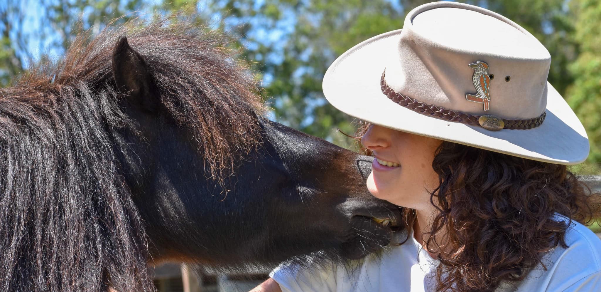 A volunteer getting up close and playing with a horse